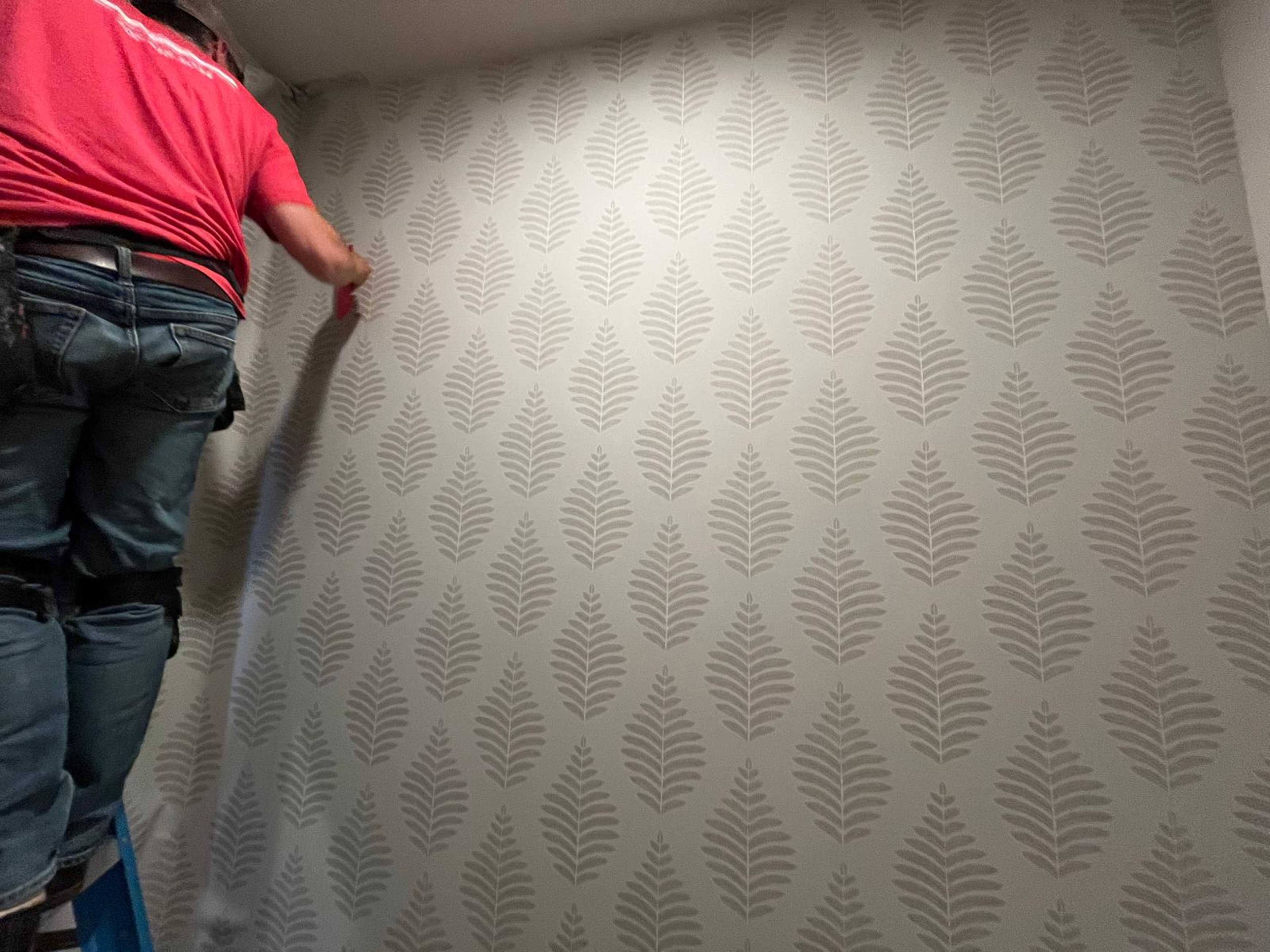 person placing a wall cover